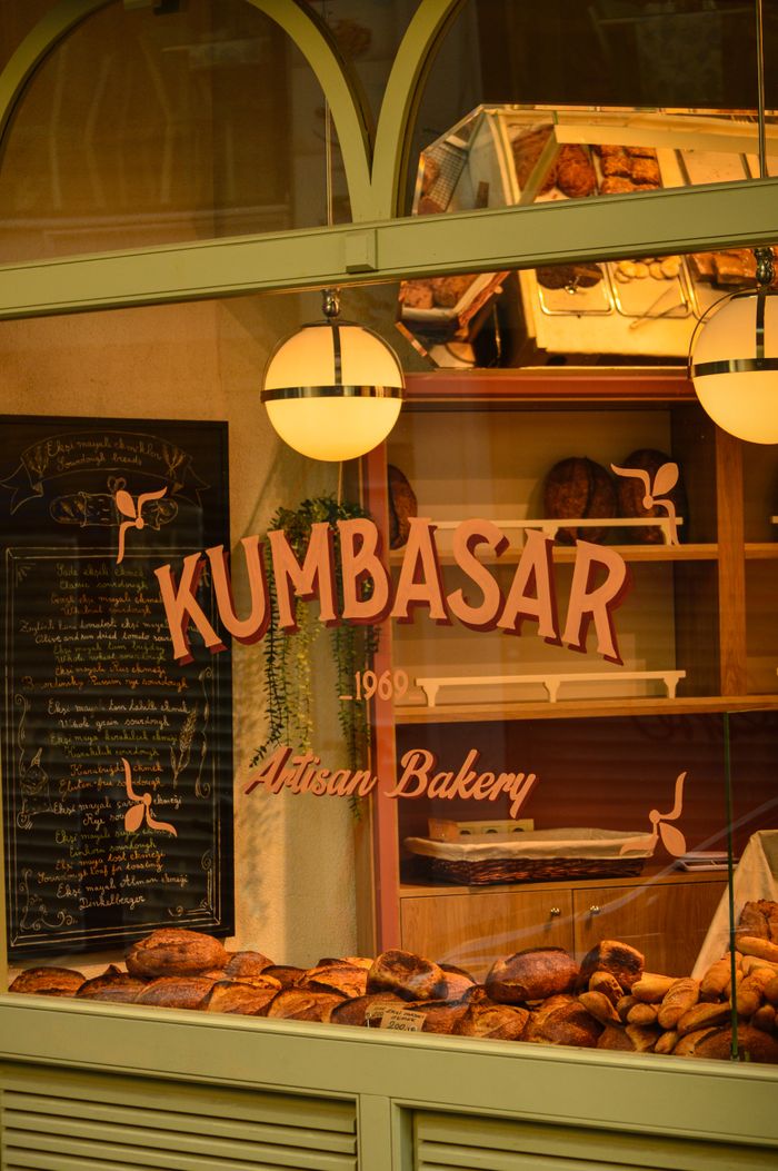 A cozy artisan bakery displaying a variety of fresh bread loaves through a window.